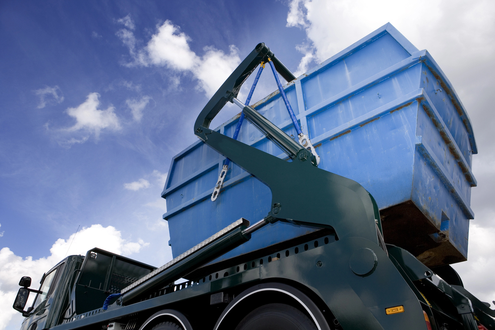 Blauwe afvalcontainer wordt afgevoerd
